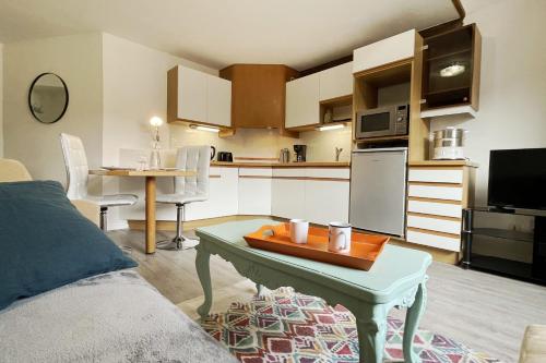 ein Wohnzimmer mit einem Tisch und einer Küche in der Unterkunft Apartment Historical City Center in Annecy