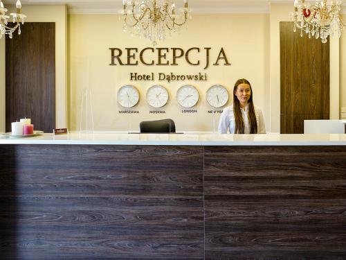 a woman sitting at a reception counter in a hotel dermatologist at Hotel Dąbrowski in Oświęcim