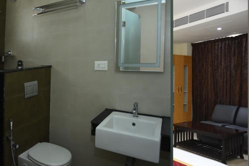 y baño con lavabo, aseo y espejo. en Masa mahal and lodge, en Sivaganga