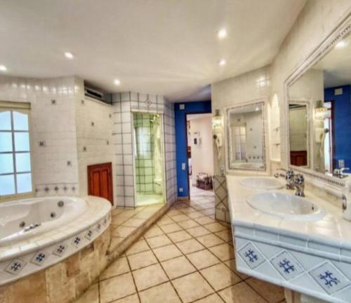 a large bathroom with two sinks and two mirrors at APARTAMENTO LUCERO beach campello in Alicante