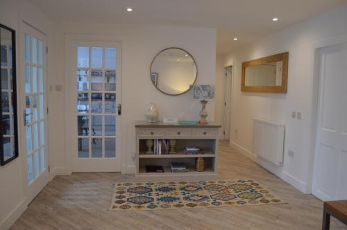 pasillo con espejo y alfombra en Makerston House Apartment Beauly, en Inverness