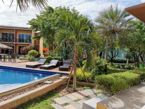 a backyard with a swimming pool and palm trees at BANGKOK.GRAND.RESORT in Bang Bo