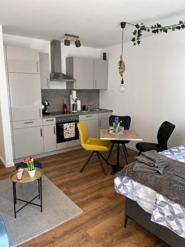 uma cozinha e sala de estar com uma mesa e cadeiras amarelas em Exklusive Ferienwohnung 5km vom Centrum em Bremen