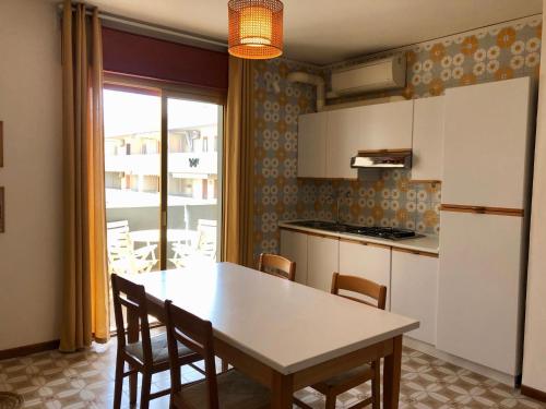 a kitchen with a table and chairs and a refrigerator at Mirafiori Apartment in Grado