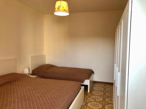 a small room with two beds and a lamp at Mirafiori Apartment in Grado