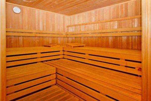 een houten sauna met houten banken en een klok bij Seehof Bansin App 21 in Bansin