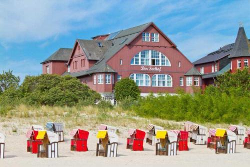 einen Strand mit Tischen und Stühlen vor einem Gebäude in der Unterkunft Seehof Bansin, App. 21 in Bansin