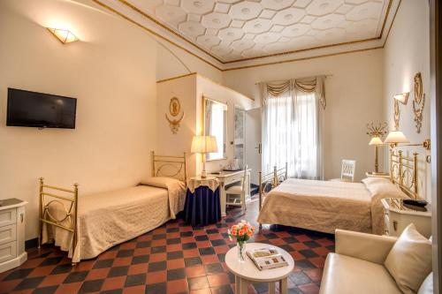a hotel room with two beds and a couch at Hotel Labelle in Rome