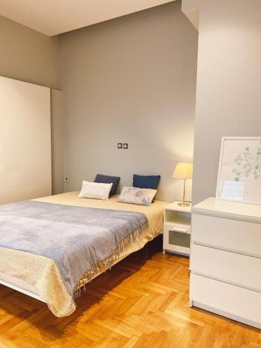 a bedroom with a bed and a dresser and a bed at Cozy Newly Renovated 1 Bedroom Apartment in the heart of Athens in Athens