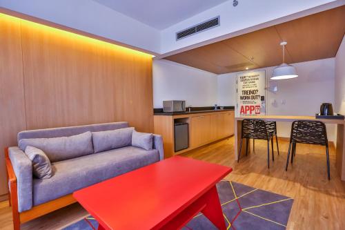 a living room with a couch and a red table at Radisson RED Campinas in Campinas
