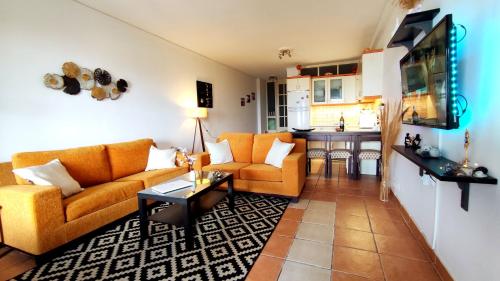 uma sala de estar com sofás laranja e uma cozinha em Nicki's House em Agia Anna (Naxos)