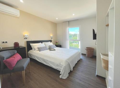 une chambre avec un lit, une chaise et une fenêtre dans l'établissement Bastidon de l'Olivaie, à Bandol