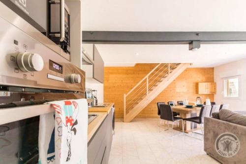 - une cuisine et une salle à manger avec un escalier dans une maison dans l'établissement Maison charmante à Pontorson avec piscine partagée, à Pontorson