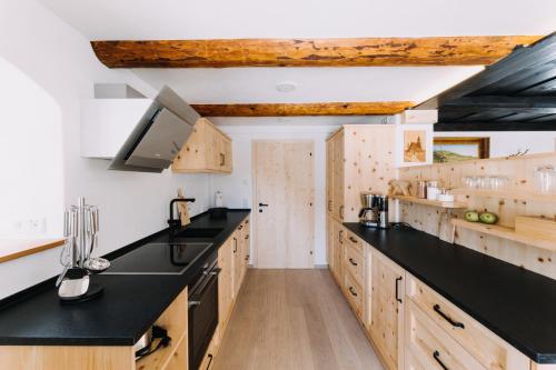 una cocina con encimeras negras y armarios de madera en Erzgebirgshaus, en Kurort Altenberg