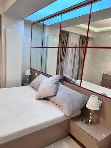 - une chambre avec un grand lit et une grande fenêtre dans l'établissement APARTAMENT LE MER TITEICA, à Floreasca