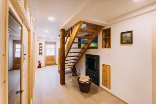 a living room with a staircase and a fireplace at Erzgebirgshaus Zirbenliebe in Kurort Altenberg