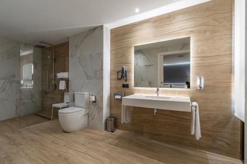 a bathroom with a sink and a toilet and a mirror at Civis Jaime I in Castellón de la Plana