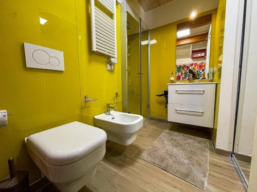 ein gelbes Badezimmer mit einem WC und einem Waschbecken in der Unterkunft Hot Peppers Apartments in Sant'Agnello