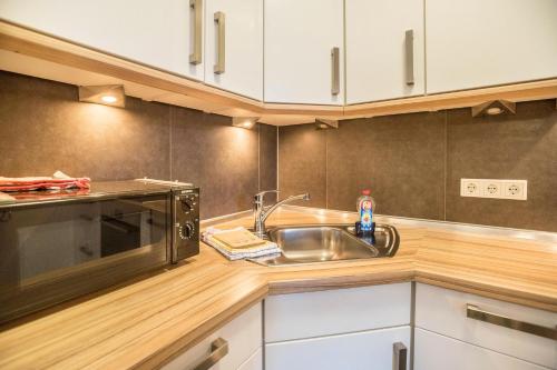 a kitchen with a sink and a microwave at Lüttje Düne in Baltrum