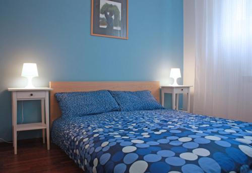 トリエステにあるEdera Residenceの青いベッドルーム(ベッド1台、ナイトスタンド2台付)