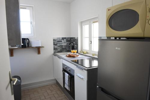 una cucina con frigorifero e forno a microonde di Le Verdier a Dieppe