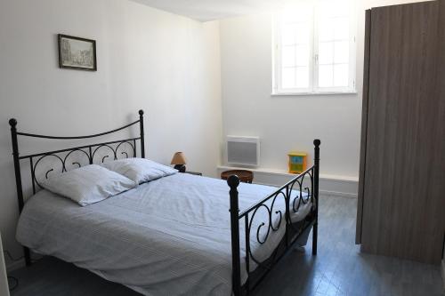 - une chambre avec un lit avec un cadre noir et une fenêtre dans l'établissement Le Verdier, à Dieppe