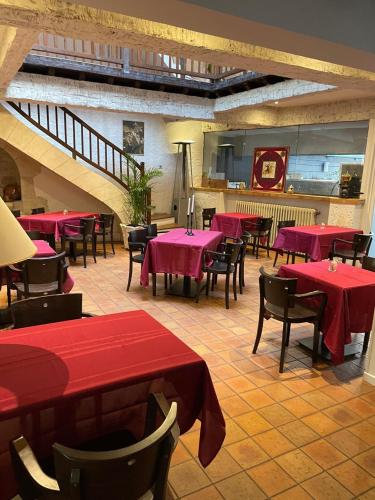 un restaurant avec des tables et des chaises rouges et un escalier dans l'établissement Le Grand Hôtel, à Souillac