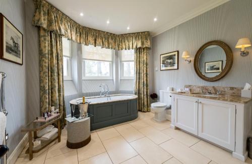 a bathroom with a tub and a toilet and a sink at The Jockey Club Rooms in Newmarket