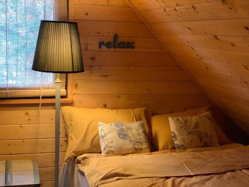a bed in a room with a roof with a lamp at ReverGrand Mazury in Marksoby