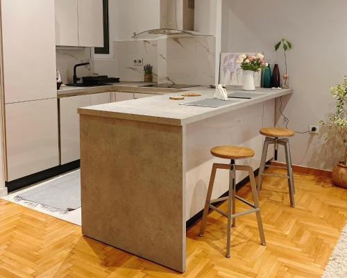 a kitchen with a counter and two stools at Cozy Newly Renovated 1 Bedroom Apartment in the heart of Athens in Athens