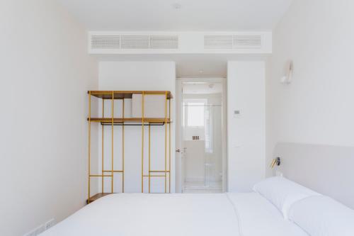 a white room with a bed and a window at The Passage Apartments in Donostia-San Sebastián