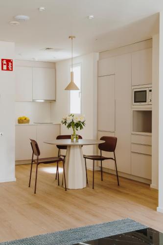 a kitchen with a table and chairs and a kitchen with white cabinets at The Passage Apartments in Donostia-San Sebastián