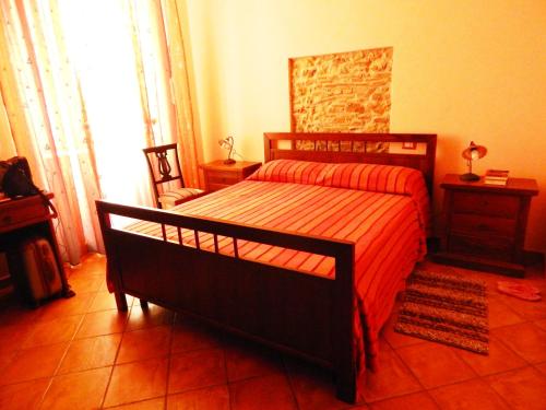 a bedroom with a bed with a red comforter at B&B Del Borgo in San Marco Argentano