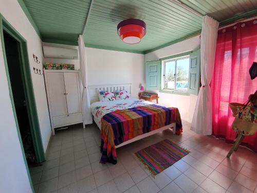 Schlafzimmer mit einem Bett und einem Fenster in der Unterkunft Baranca Stima in Aldeia de Além