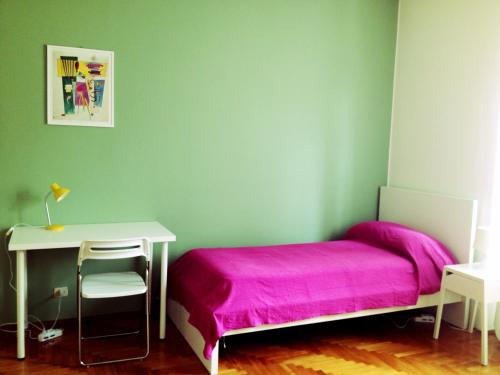 a bedroom with a pink bed and a desk at Casa Julia in Cividale del Friuli