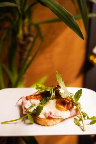 a white plate with a sandwich with greens on it at D-Palace-Adriatic in Donji Zemunik