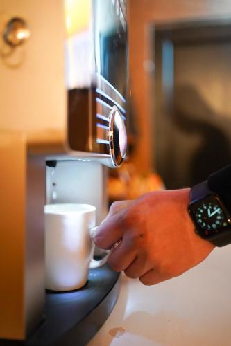 a person is pouring coffee into a cup at D-Palace-Adriatic in Donji Zemunik
