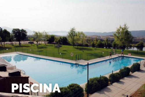 a large swimming pool with a park in the background at Sol Badaguas Jaca in Jaca