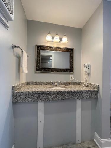 a bathroom with a sink and a mirror at Rio Motel and Suites in Wildwood