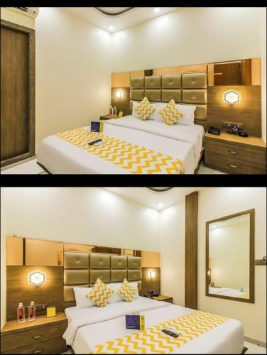 a hotel room with two beds and a mirror at Hotel Guestinn Residency in Mumbai