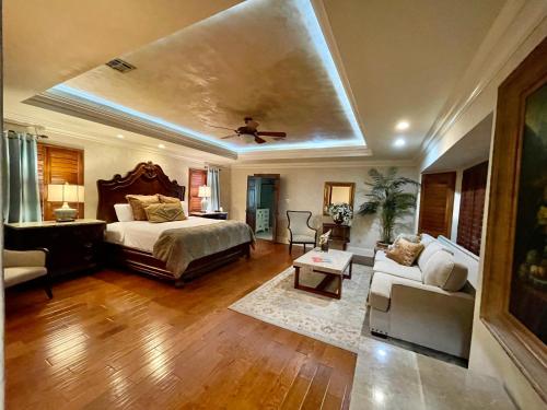 a bedroom with a bed and a couch in a room at Louisiana Cajun Mansion in Youngsville