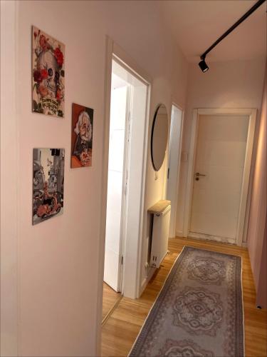 un corridoio con una porta e alcuni quadri sul muro di Vins Apartment a Pristina