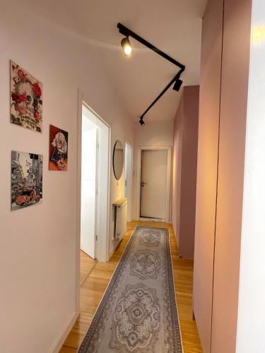 un corridoio con un tappeto sul pavimento e una porta di Vins Apartment a Pristina