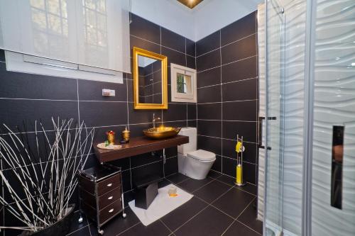 a bathroom with a sink and a toilet and a mirror at Villa Victoria Barcelona in Barcelona