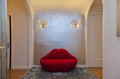 a red chair sitting on a rug in a hallway at Villa Victoria Barcelona in Barcelona
