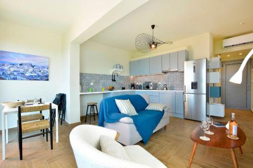 a living room with a blue couch and a kitchen at Kommeno Blue Bay Apt. in Kommeno