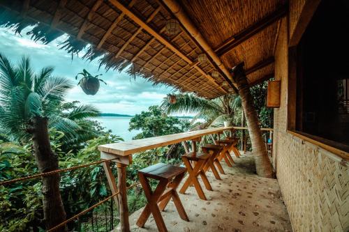 a porch of a resort with chairs and a view of the ocean at Cocovana Beach Resort in Busuanga