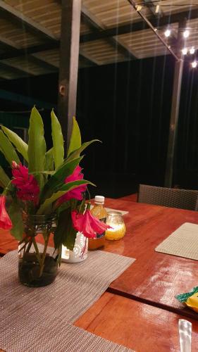 une table en bois avec un vase et des fleurs. dans l'établissement Jungle Eco Reserve, à Colón