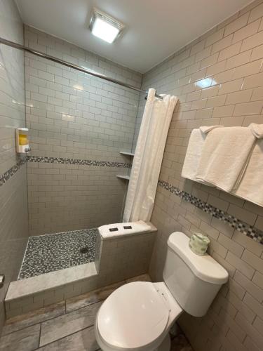 a white bathroom with a toilet and a shower at Rio Motel and Suites Wildwood Beach & Boardwalk in Wildwood