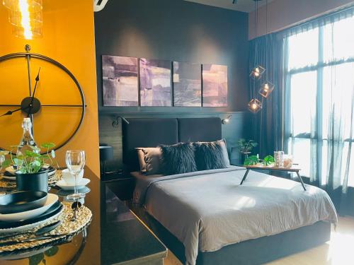 a bedroom with a bed and a table with plates and glasses at Serene Studio Imperium Residence Kuantan in Kuantan